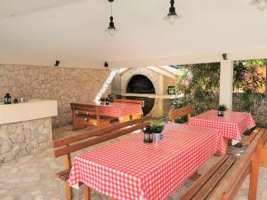 a restaurant with two tables with red and white table cloth at Lenka Apartments I in Novalja