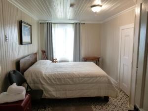 a bedroom with a bed and a window at La Maison entre Mer Montagnes in Cap-Chat