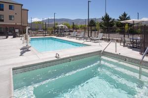 a large swimming pool with chairs and a table at Staybridge Suites - Carson City - Tahoe Area, an IHG Hotel in Carson City