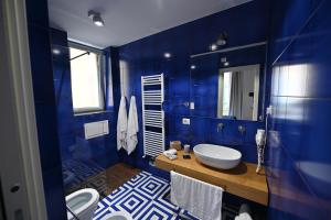 Un baño azul con lavabo e inodoro. en La Memolina B&B, en Salerno 27 fotos más