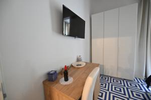 a room with a wooden table with a tv on the wall at La Memolina B&B in Salerno