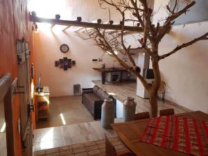 sala de estar con mesa y árbol en Posada Villa Aurorita, en Famatina