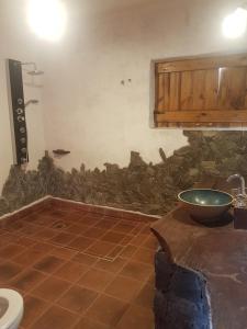 baño con pared de piedra y lavamanos en Posada Villa Aurorita, en Famatina