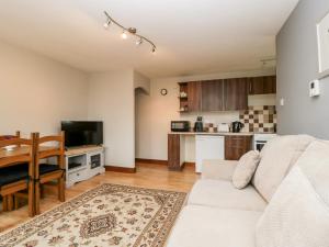 uma sala de estar com um sofá branco e uma mesa em Wisteria Chalet em Cote