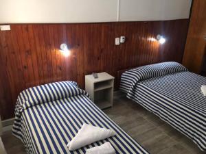 2 camas en una habitación con paredes de madera en Hotel Mar Del Plata en Termas de Río Hondo