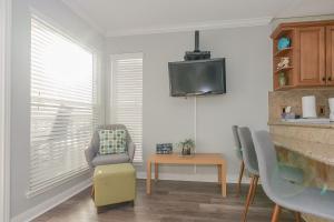 a living room with a tv and a chair and a table at Beautiful Seascape Condo with Great Views of the Gulf in Galveston