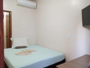 リオ・ベルデにあるHotel Por Do Solのベッドルーム(白いベッド1台、枕付)