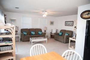 a living room with a couch and chairs and a table at 57218 Island Club Lane Home in Hatteras
