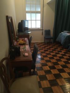 uma sala de estar com uma mesa e um piso em xadrez em Petrópolis Palácio Quitandinha em Petrópolis