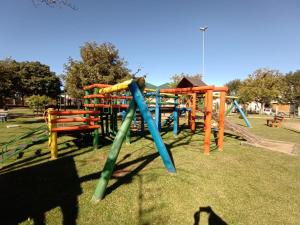 a park with a colorful playground with a slide at CASA OTTON - Casa aconchegante, 3 quartos com cama de casal todos com ar condicionado in Gramado