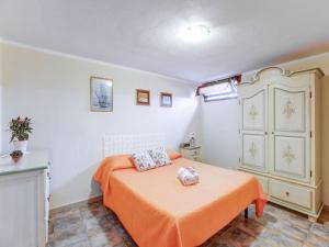 um quarto com uma cama com um cobertor laranja em Belvilla by OYO CASA MELIS em Carbonia