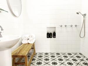 La salle de bains blanche est pourvue d'un lavabo et d'une douche. dans l'établissement Castlebar - Superior Boutique Accomodation - Steps to Pakington Street, à Geelong West