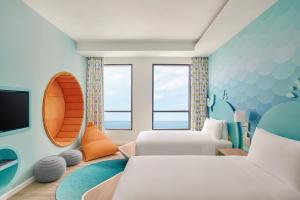 a hotel room with two beds and a tv at Holiday Inn Resort Ho Tram Beach by IHG in Ho Tram