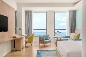 a hotel room with a bed and a living room at Holiday Inn Resort Ho Tram Beach by IHG in Ho Tram