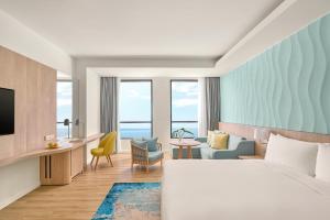 a hotel room with a bed and a room with a view at Holiday Inn Resort Ho Tram Beach by IHG in Ho Tram