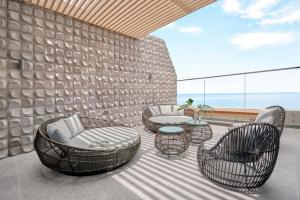 a patio with chairs and tables on a balcony at Holiday Inn Resort Ho Tram Beach by IHG in Ho Tram