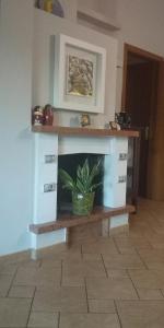 een open haard in een woonkamer met een potplant bij La Casetta sul Camposcuola in Teramo