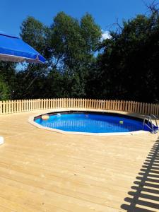 a small swimming pool with a wooden fence at Cabana din livada cu ciubar in Pucioasa