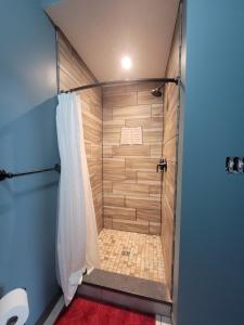 a walk in shower in a bathroom with blue walls at The Colburn Schoolhouse - Literature Suite in Sandpoint