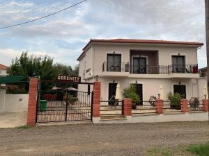 a white house with a gate in front of it at Serenity Studios in Kala Nera