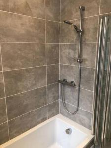 Das Bad ist mit einer Dusche und einer Badewanne ausgestattet. in der Unterkunft Beautiful Scandi-Inspired one bed in Stockbridge in Edinburgh