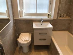 ein Badezimmer mit einem Waschbecken, einem WC und einer Badewanne in der Unterkunft Beautiful Scandi-Inspired one bed in Stockbridge in Edinburgh