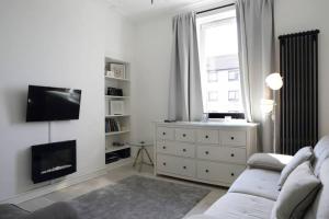 ein weißes Wohnzimmer mit einem Sofa und einem Kamin in der Unterkunft Beautiful Scandi-Inspired one bed in Stockbridge in Edinburgh