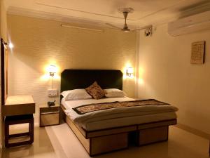 a bedroom with a bed with two lights on it at Hotel Saluja in Siliguri