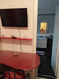 a room with a red table and a television on the wall at Casa Silvia in Caltagirone