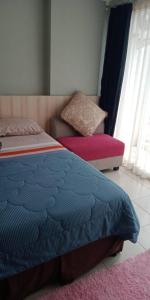 a bedroom with a bed and a bench in a room at Altiz Apartment Bintaro Plaza Residence in Tangerang