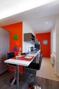 ストラスブールにあるアパルトマン コム シェ ソワの赤とオレンジの壁のキッチン