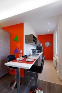 a kitchen with a red and orange wall at Appartement Comme Chez Soi in Strasbourg