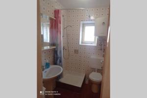 baño con lavabo y aseo y ventana en Kuća za odmor Ljubica Šibenik en Šibenik