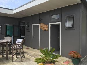 Casa con patio con mesa y sillas en Kiwi Cabins en Tapu