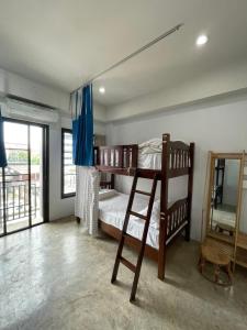 a bedroom with two bunk beds and a ladder at Bake Room Hostel in Chiang Mai