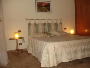 a bedroom with a bed with two lamps on it at B&B Le Palme in Bassano Romano