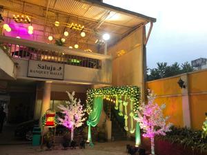 um edifício com luzes de Natal e árvores em frente em Hotel Saluja em Siliguri