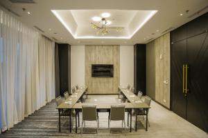 a conference room with a long table and chairs at Awann Sewu Boutique Hotel and Suite Semarang in Semarang