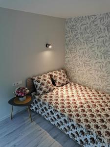 - une petite chambre avec un lit et une table dans l'établissement Upės apartamentai, à Biržai