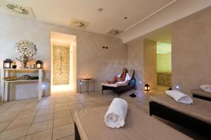 a woman sitting in a chair in a living room at Hotel Villa Durrueli Resort & Spa in Ischia