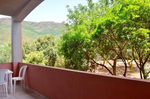 a balcony with a table and chairs and trees at Hotel Golfo del Leone in Portixeddu