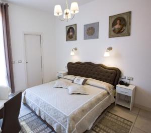 a bedroom with a large bed and a chandelier at Hotel Arcoveggio in Bologna