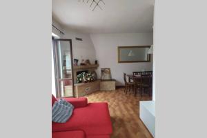 ein Wohnzimmer mit einem roten Sofa und einem Tisch in der Unterkunft Appartamento nel verde tra Cinque Terre e Versilia in Barbarasco