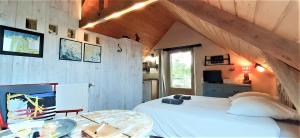 ein Schlafzimmer mit einem großen weißen Bett und einem Tisch in der Unterkunft La grange aux lièvres, gîtes Kerdoel in Cléder