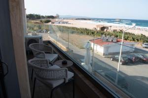 a balcony with two chairs and a view of a beach at Vila Gama in Lozenets
