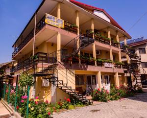 a building with stairs and flowers in front of it at Vilele violeta in Mamaia Sat/Năvodari