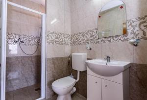a bathroom with a toilet and a sink and a shower at Vilele violeta in Mamaia Sat/Năvodari +27 photos