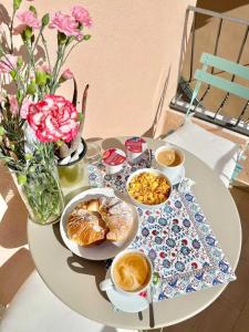 een tafel met ontbijtproducten en koffie en een vaas met bloemen bij Loraia Design Rooms in Porto Ercole