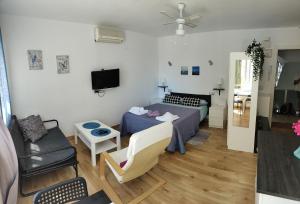 mały salon z łóżkiem i kanapą w obiekcie Solaz-Andaluz City Center Apartment BY NAMASTE ELITE w mieście Torremolinos