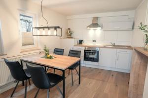 een keuken en eetkamer met een tafel en stoelen bij Das Hölderlein - Altstadthotel in Nürtingen